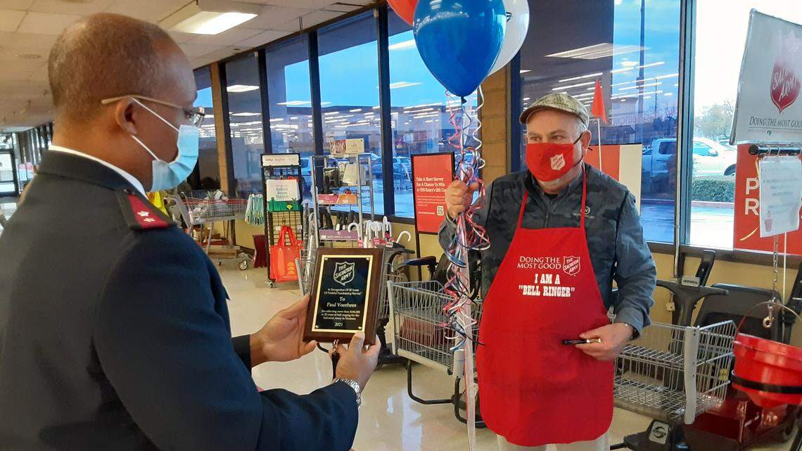 Salvation Army Capt. Samuel Snyder presents Paul Voorhees with a plaque Wednesday at the Raley’s at Tully Road and Standiford Avenue in recognition of Voorhees’ 20 years as a red kettle bell ringer.