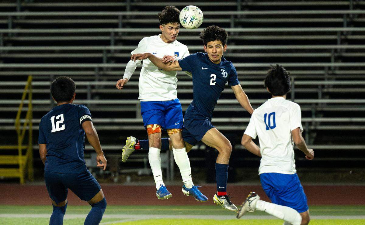 Turlock’s Luis Llamas and Downey’s Aminadad Villanueva clash on a header during the Central California Athletic League game at Downey High School in Modesto, Tuesday, Jan. 28, 2025. The game ended in a 1-1 tie.