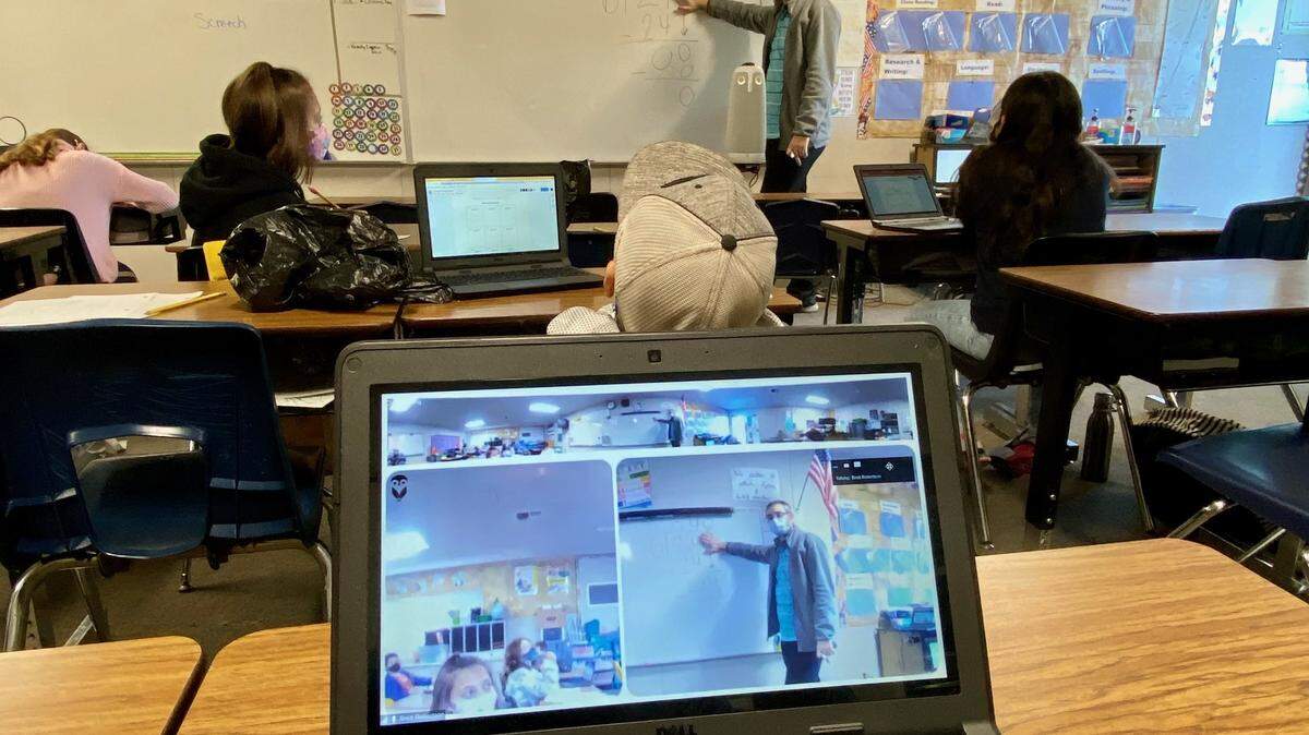 Fifth-grade teacher Brett Robertson uses an “Owl” camera, center, to teach Fox Road Elementary School students online and in person simultaneously.
