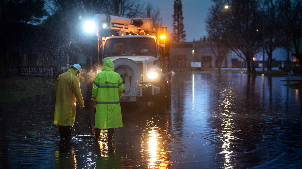Trabajadores de la ciudad de Modesto despejan el agua de lluvia de Cummins Drive en Modesto, California, el jueves 28 de enero de 2021.