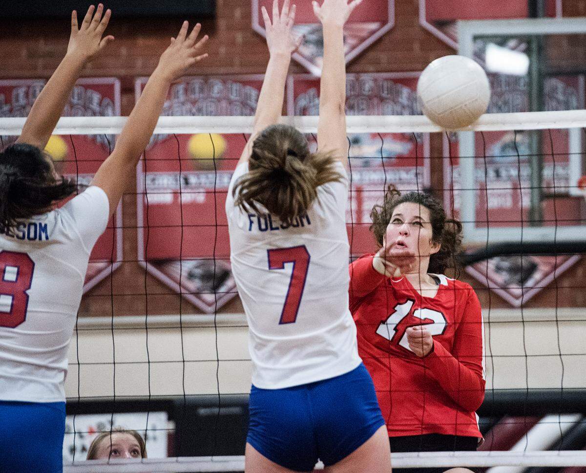 Modesto’s Shelby Benz (12) spikes the ball past Folsom’s Sydney Radell during the Sac Joaquin Section playoff game at Modesto high School in Modesto, Ca., on Tuesday, Oct. 23, 2018.
