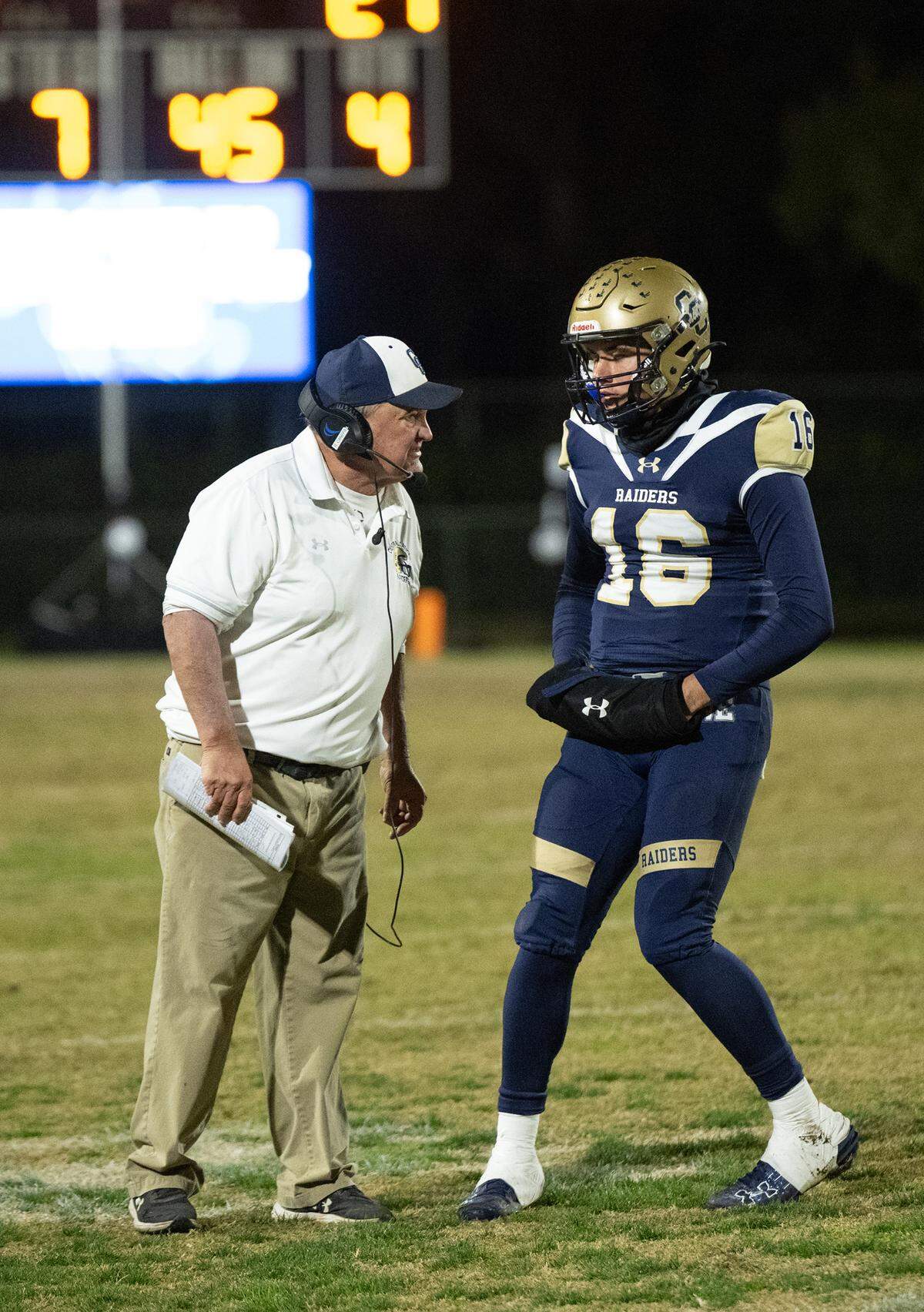 Central Catholic head coach Roger Canepa gives quarterback Kayden McHenry an offensive play during the Sac-Joaquin Section Division I playoff game with Turlock at Central Catholic High School in Modesto, Friday, Nov. 15, 2024.