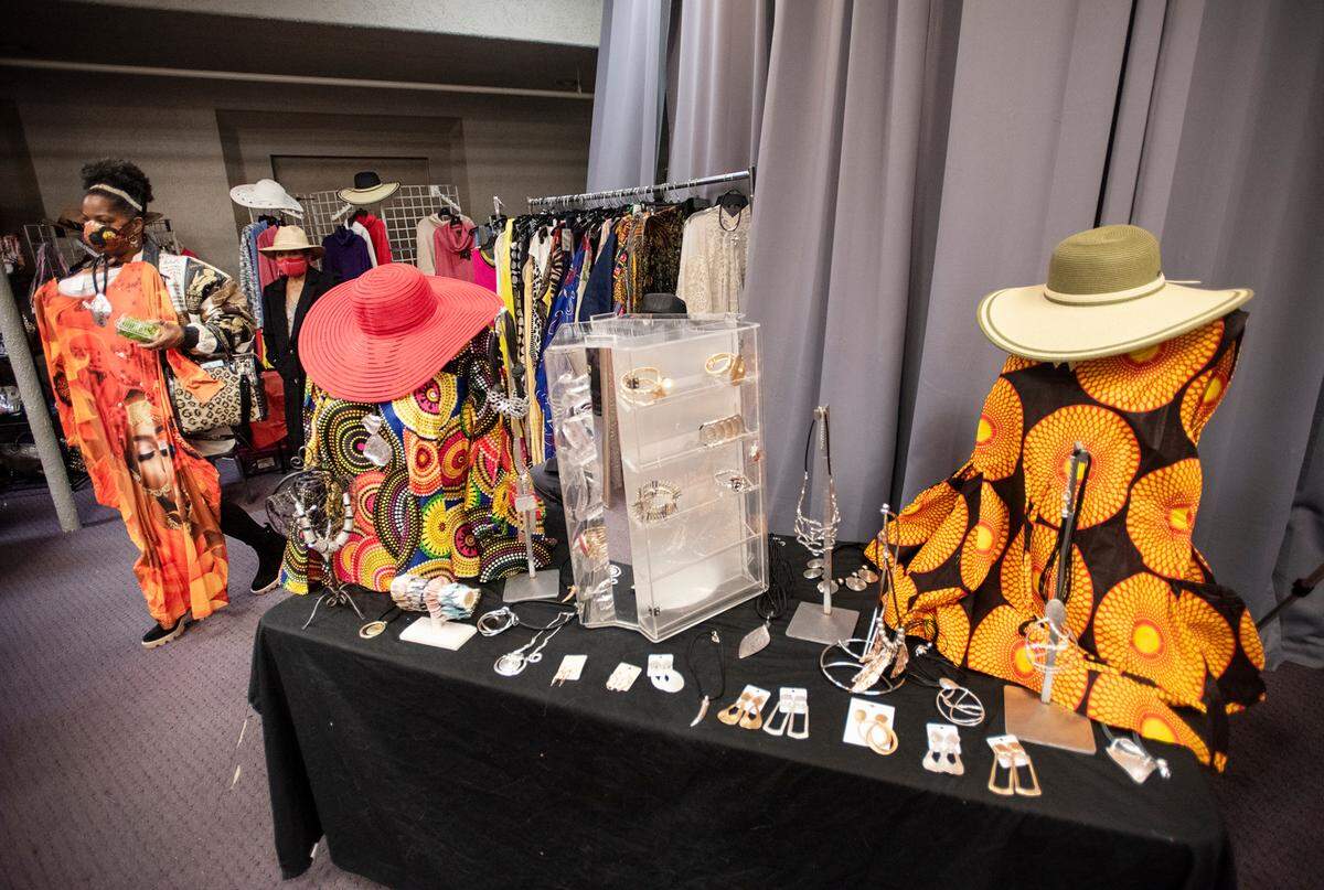 Jacquelyn Forte, left, looks at a dress from one the vendors during the Modesto-Stanislaus NAACP Holiday Kwanzaa Social at Redeemer Modesto in Modesto, Calif., on Friday, Dec. 10, 2021.