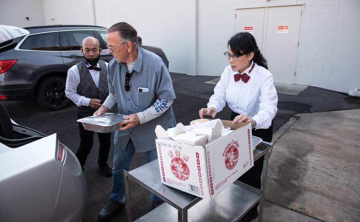 Owner Maria Wong, right, helps Garrad Marsh with a catering order at Beijing Restaurant in Modesto, Calif., Thursday, Dec. 15, 2022.