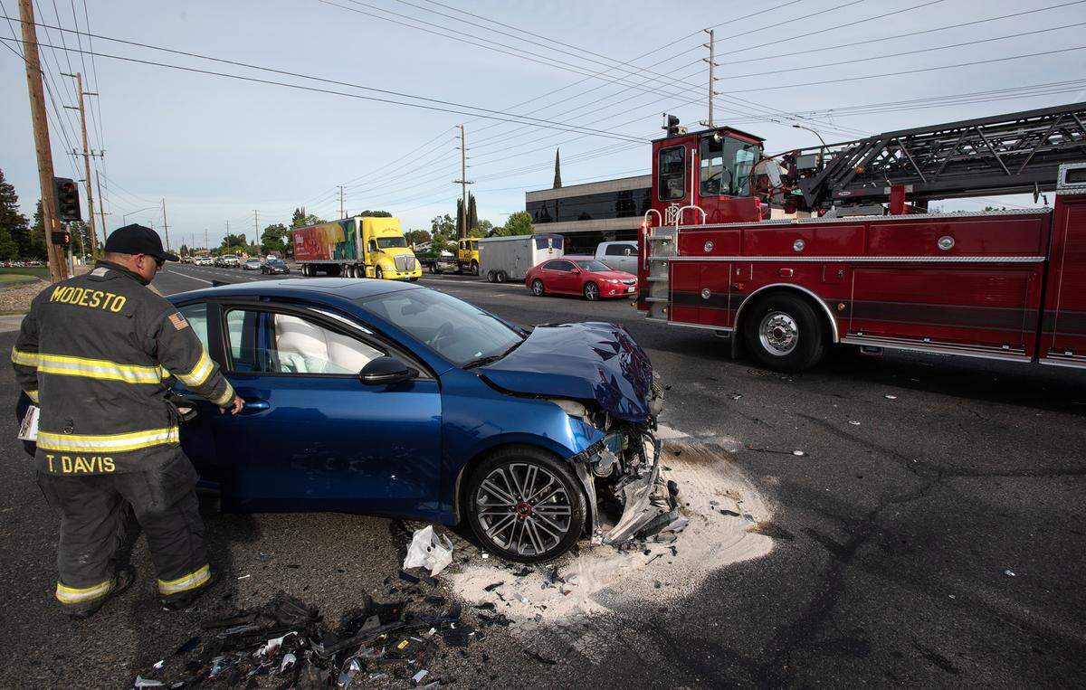 A Modesto firefighter checks a car after a crash on Coffee Road and Briggsmore Avenue in Modesto, Calif., on Thursday, May 5, 2022.