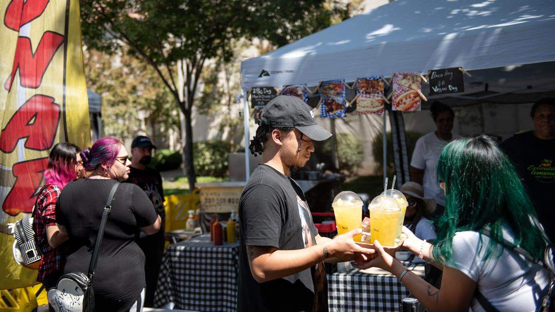 Christian Vargas, left, and Jessica Gonzalez pickup some lemonade at the downtown farmers market in Modesto, Calif., on Thursday, September 1, 2022.
