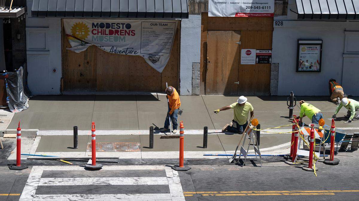 Concrete workers finish the expanded sidewalk outside the future Modesto Children’s Museum in Modesto, Calif., Wednesday, May 17, 2023.