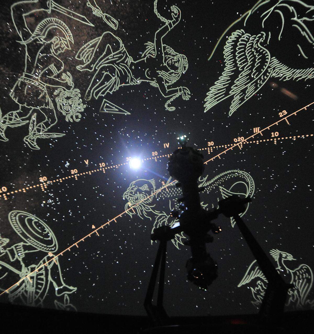 The state of the art Carl Zeiss Velvet star projector is silhouetted by its images of the night skies along with zodiac constellations superimposed onto Modesto Junior College’s West Campus planetarium.