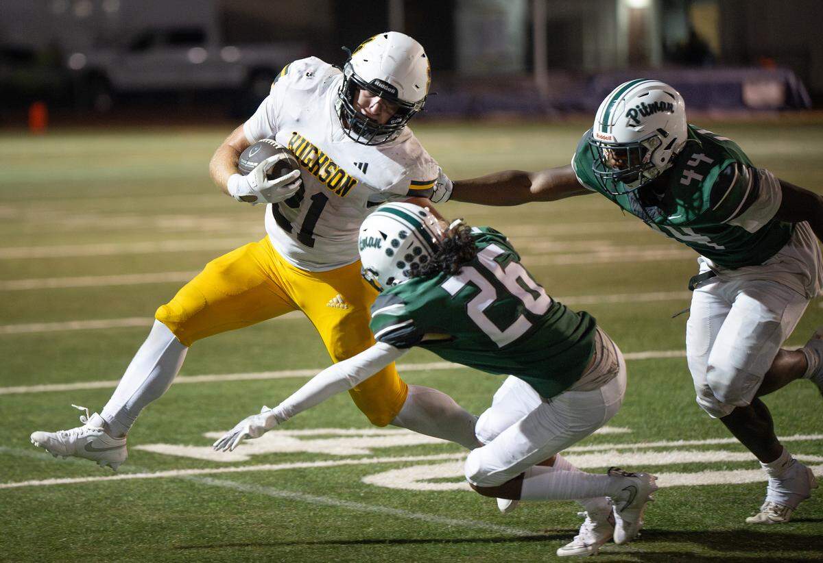 Hughson’s 	Eli Wilbanks breaks toward the sideline as he is pursued by Pitman defenders 	DAngelo Ahedo (26) and Jordan Riley (44) at Turlock High School in Turlock on  Friday, Sept. 5, 2025.