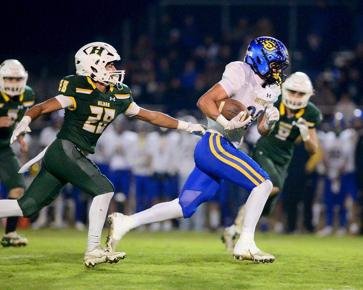 Sutter Huskies running back Max Bringgold (22) runs away from a Hilmar defender during a Sac-Joaquin Division V semifinal game in Hilmar on Friday.