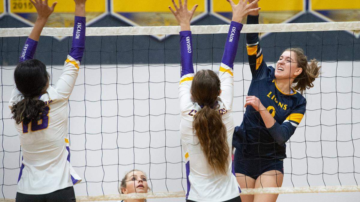 Big Valley Christian’s Alexis Roest spikes the ball past Escalon defenders during the non-league match at Big Valley Christian High School in Modesto, Calif., on Monday, Oct. 4, 2021.