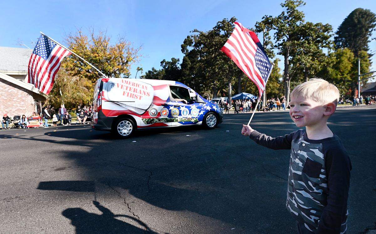 Cameron Coulie, 3, waves a flag during the Veterans Day Parade in Modesto, Calif., Saturday, Nov. 11, 2023.