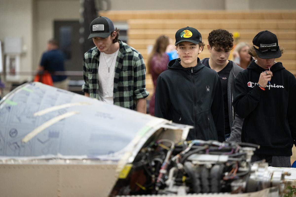 Beyer High School student Fredy Khela, middle, looks over a small aircraft during Construction Trades Day at the Modesto Junior College West Campus in Modesto, Calif., Wednesday Nov. 15, 2023. The event was organized by the Valley Builders Exchange, a Modesto-based group that helps contractors with hiring and training.