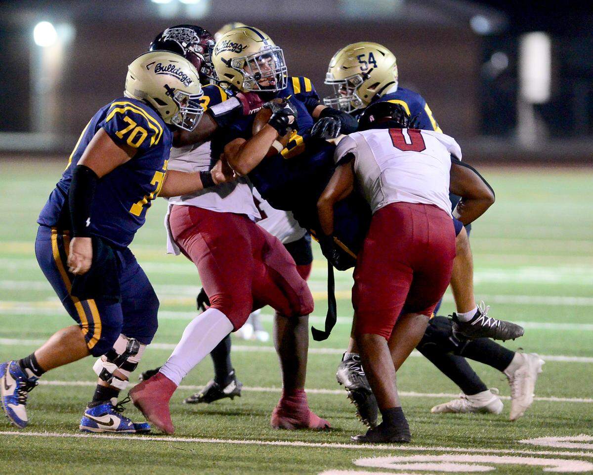 Turlock receiver Leo Contreras (3) gets tackled by two Laguna Creek defenders during a Division 1 CIF San-Joaquin Section playoff game between Turlock High School and Laguna Creek High School at Turlock High School in Turlock California on November 8, 2024. Turlock won the game 48-12.