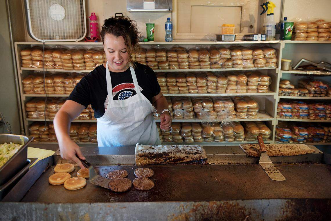 Sarah Coey tends to burgers at VFW Ladies Auxiliary hamburger booth at the Stanislaus County Fair in Turlock, Calif., Saturday, July 14, 2018.