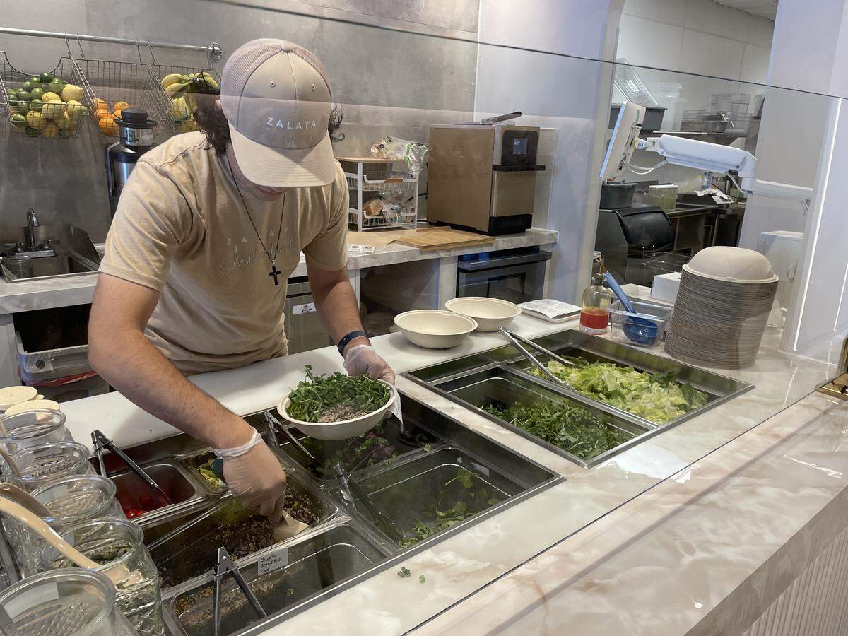 An employee makes a salad at Zalata, a new healthy cafe in Turlock on Thursday, April 23.