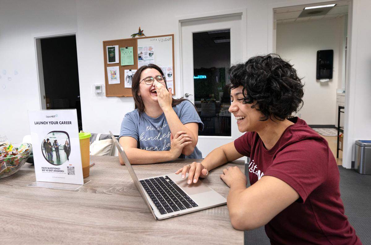 La especialista en miembros Gabriela Díaz, a la derecha, y Francesca Immediato, a la izquierda, se ríen antes de una reunión de grupo en Digital NEST, en Modesto, California, el miércoles 13 de septiembre de 2023.