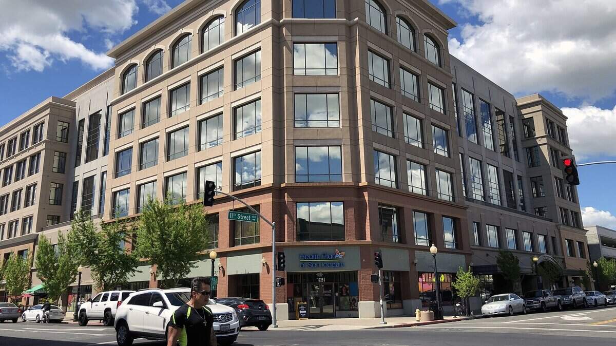 Clouds are reflected in the glass windows at Tenth Street Place, the city/county building in downtown Modesto, Calif. on April 9, 2019.