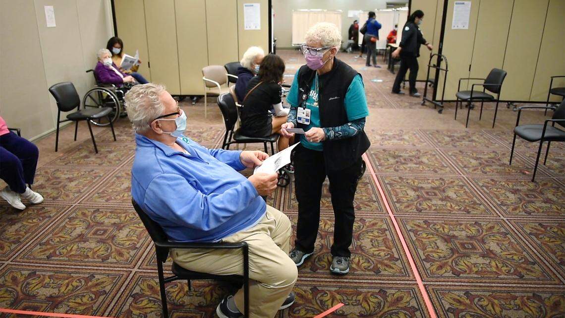 Sutter Health registered nurse Lynn Mendoza talks with Leonard Churilla as she monitors a group of seniors who received the COVID-19 vaccine during an appointment only clinic for its members in Modesto, Calif., on Wednesday, Feb. 10, 2021. Patients are monitored for a period of 15-30 minutes after receiving the vaccine.