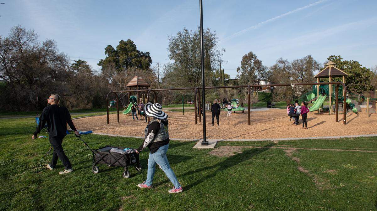Families enjoy the warm weather at the new playground at East La Loma Park in Modesto, Calif., on Friday, March 5, 2021.