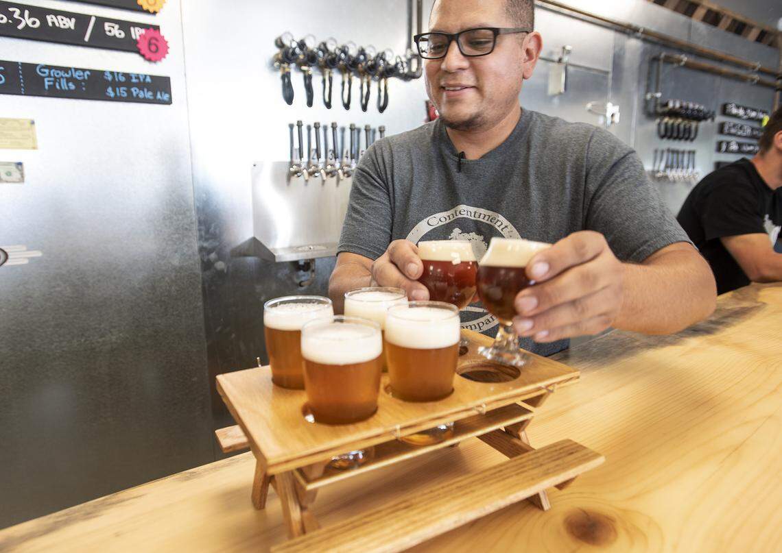 Alejandro Serrato brewer and owner serves up a flight of beer at Contentment Brewing Company in Modesto, Calif., Friday, July 19, 2019.