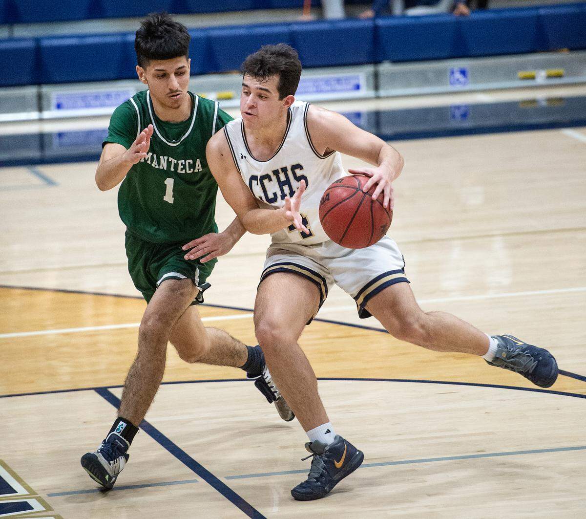 Central Catholic’s Arthur Avila drives toward the basket as Manteca’s Ramesh Kabiri defends during the Valley Oak League game at Central Catholic High School in Modesto, Calif., on Wednesday, Feb. 9, 2022. Manteca won the game 39-33.