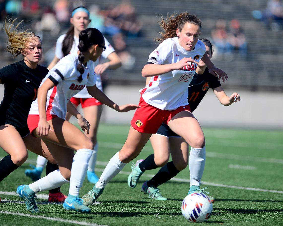 Oakdale’s Dakota Burford (12) sprints away from Roseville defenders during the Sac-Joaquin Section Division III Championship between Oakdale High School and Roseville High School at Cosumnes River College in Sacramento, Calif. on Saturday, March 1, 2025.