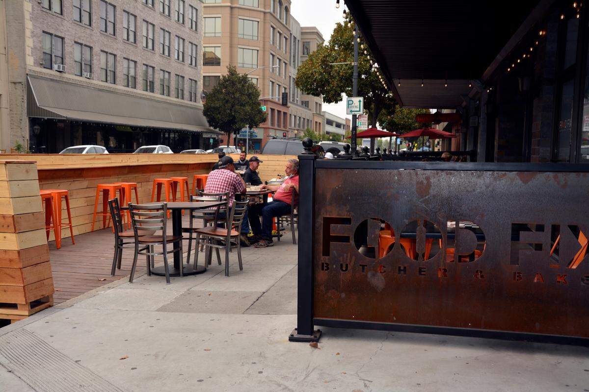Diners sit in a parklet built in a parking space in front of Food Fix restaurant on 11th Street in downtown Modesto, Calif Sept. 10, 2020.
