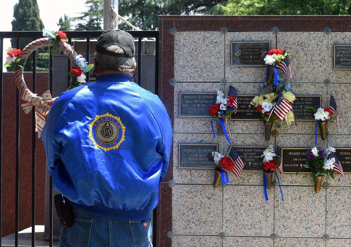 A veteran pays his respects at a memorial wall Monday morning, May 27, 2019, at Acacia Memorial Park in Modesto, Calif.