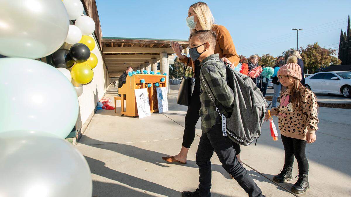 Parents drop off students at Sonoma Elementary School in Modesto, Calif., on Thursday, Nov. 12, 2020. First preschool through second-grade students returned to classrooms after months of distance learning due to the coronavirus restrictions.