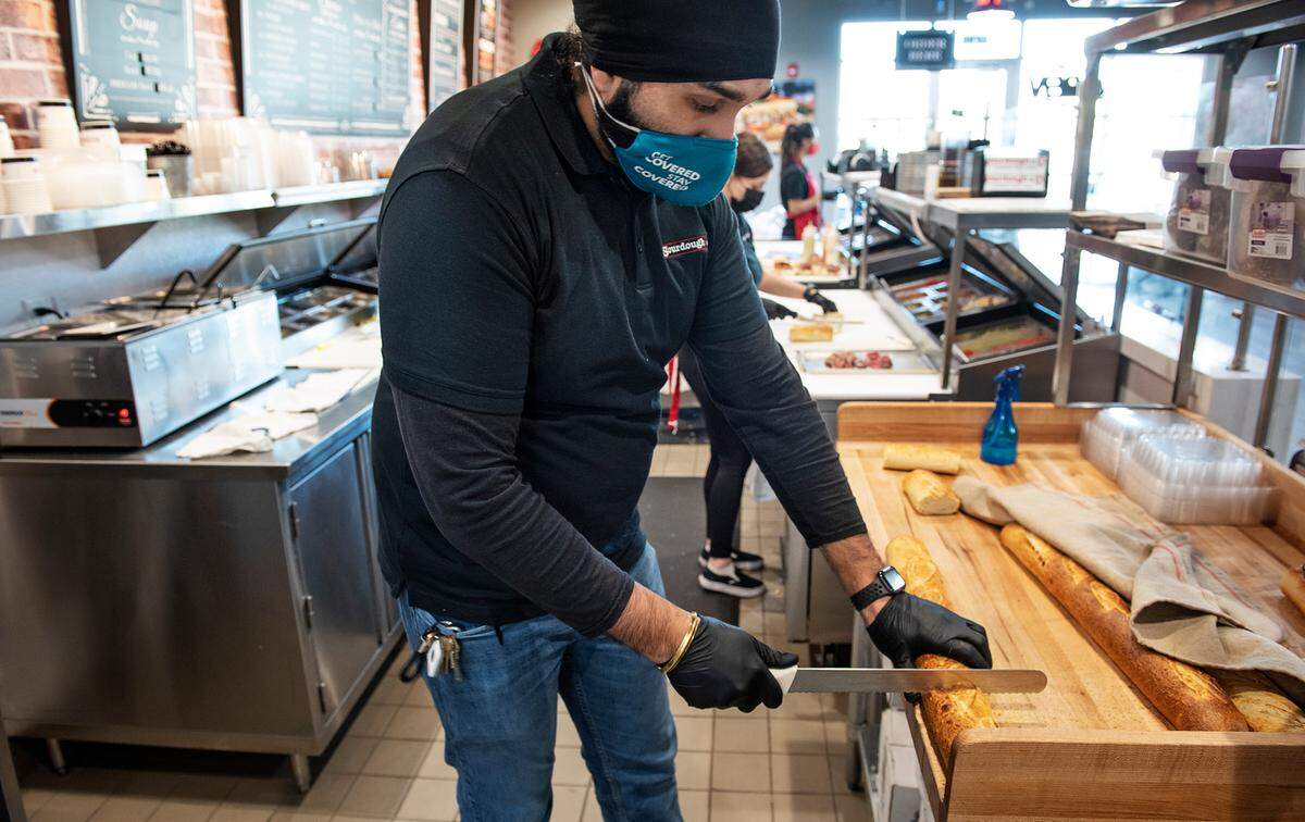 Owner DJ Singh cuts freshly baked sourdough bread at Sourdough & Co. in Turlock, Calif., on Thursday, March 4, 2021.