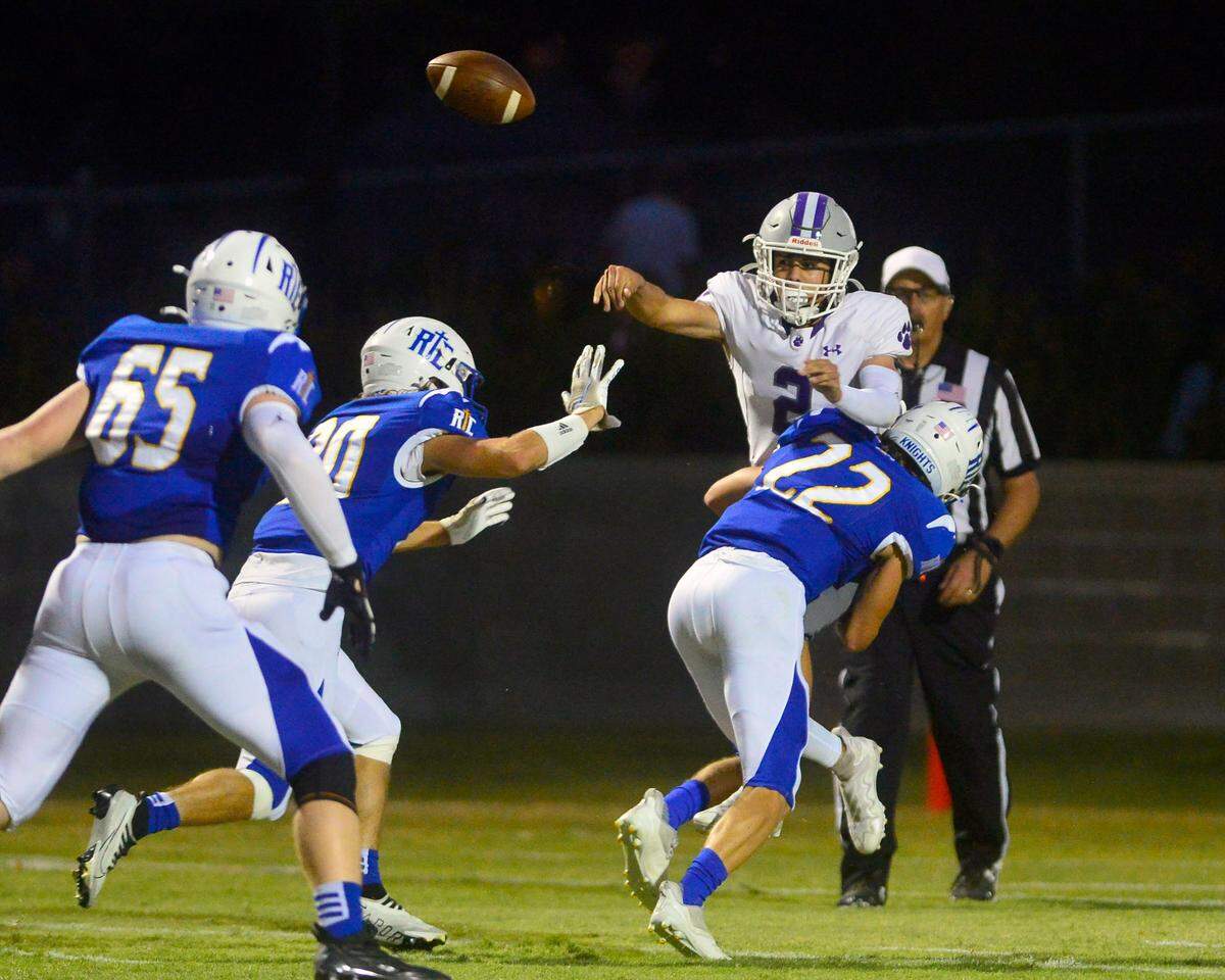 Denair quarterback Landen Borges thorws the ball as he is hit by RC defender Derek VanElderen (22) during a game between Ripon Christian and Denair at Ripon Christian High School in Ripon California on September 16, 2022.