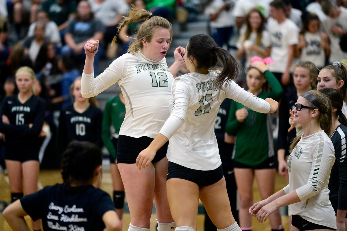 Pitman teammates Madison King (12) and Emma Hirschkorn (11) get pumped before the game with a chest bump, during the senior night, crosstown volleyball matchup of Turlock High at Pitman High, on Monday, Oct., 15 in Turlock, California.