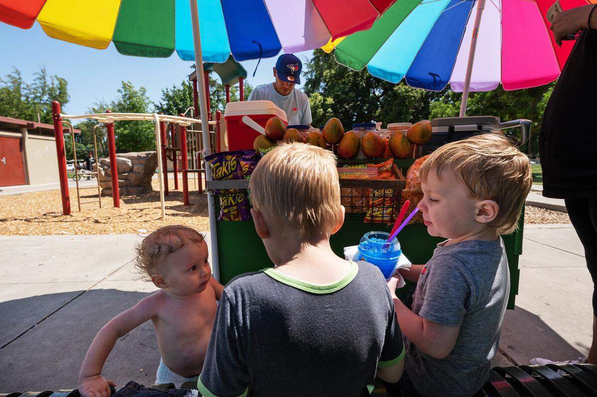Brothers Dakota, 5, Bentley, 3, right and Ezekiel, 1, take a break from playing in the water feature at Marshall Park in Modesto, Calif., Thursday, June 1, 2023.