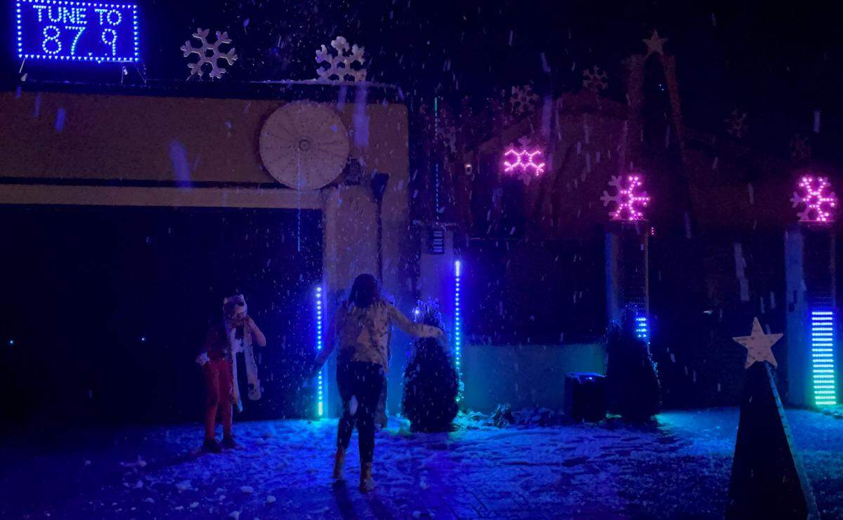 People play in the falling snow at the Esakhnai home in Turlock on Friday night, Dec. 10, 2021
