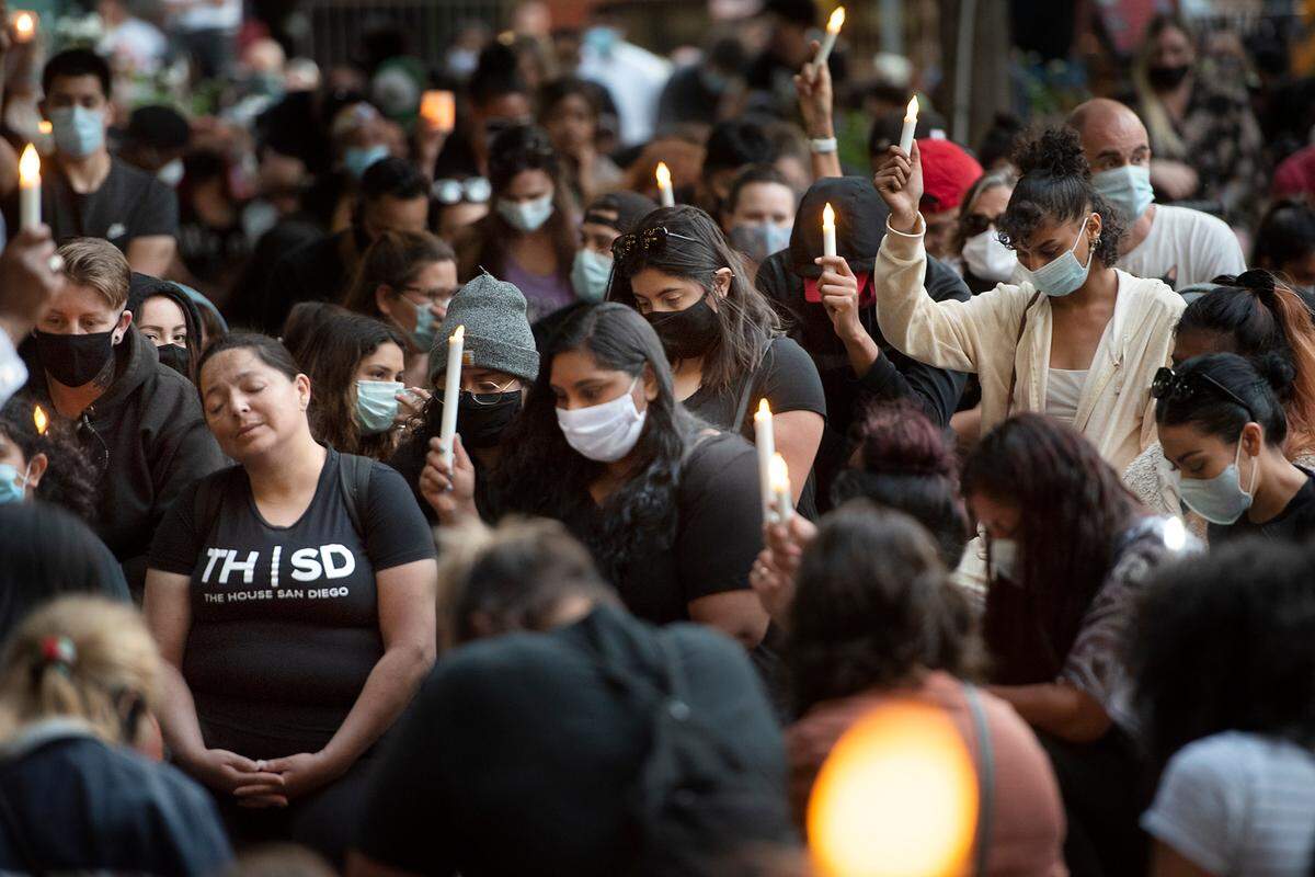 Attendees kneel on the brick pavement for 8 minutes and 46 seconds in an extended moment of silence during a candlelight vigil for George Floyd at 10th Street Place in Modesto, Calif., on Friday, June 5, 2020. 8 minutes and 46 seconds is the time that prosecutors say Floyd was pinned to the ground by a Minneapolis police officer before he died last week in Minnesota.