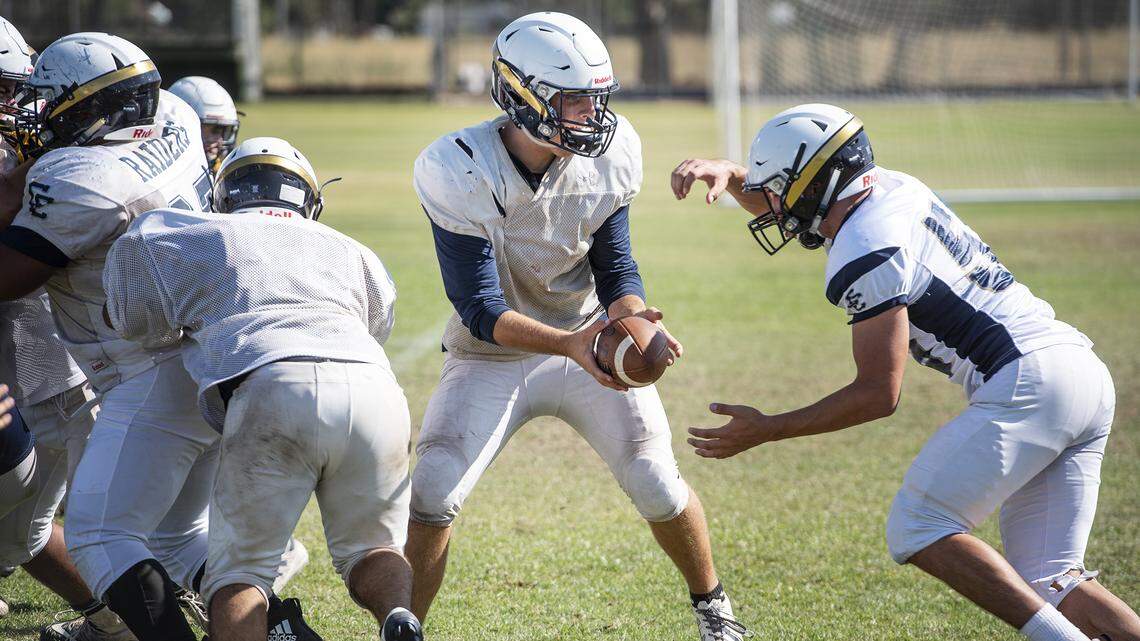 Central Catholic quarterback Dalton Durossette, middle, hands the ball off during practice at Central Catholic High School in Modesto, Calif., Friday, Aug. 9, 2019.