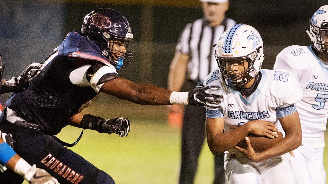 Modesto Christian’s Xavier Carlson, left, gets a hand on El Capitan’s Samuel Evans (21) during their game in September 2018.