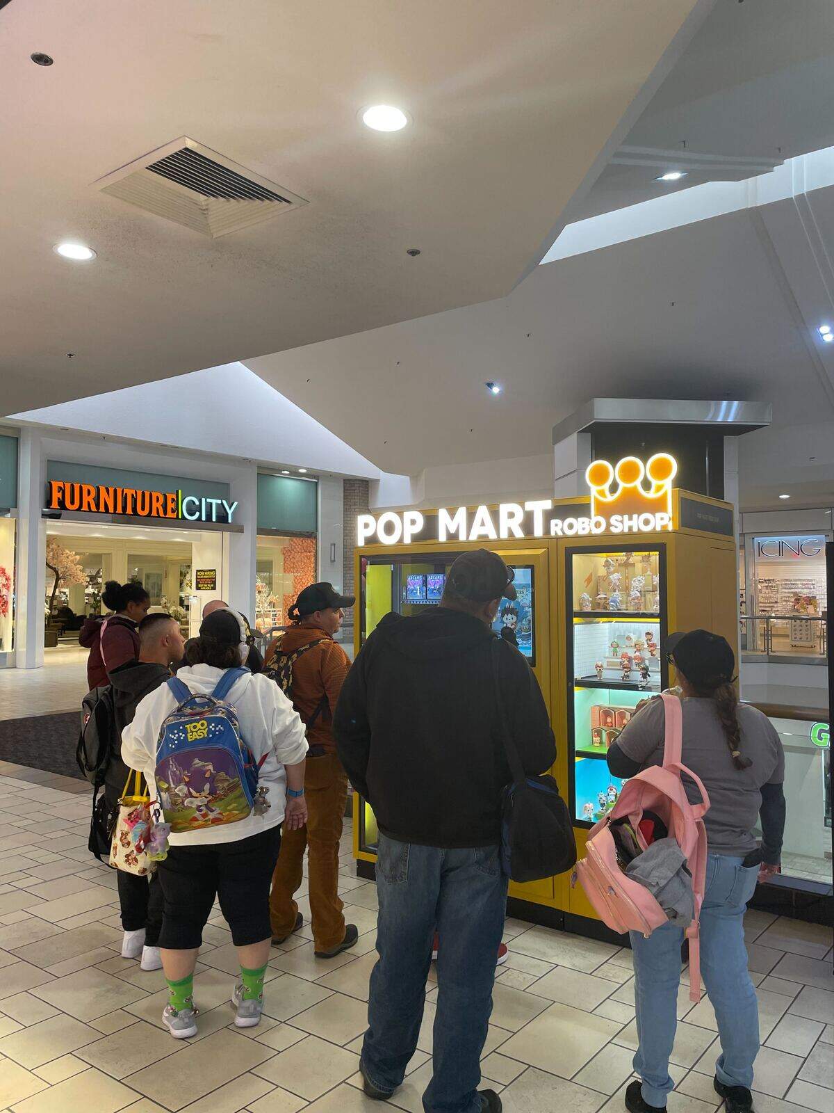 A group of shoppers checks out the new Pop Mart Robo Shop vending machine at  Vintage Faire Mall on Tuesday, Oct. 14.