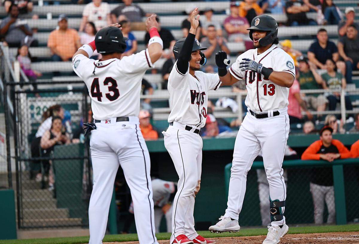 Modesto Nuts’ Freuddy Batista (13) celebrates a three-run homer with Harry Ford and Milkar Perez (43) during the opening day game with the San Jose Giants at John Thurman Field in Modesto, Calif., on Friday, April 8, 2022. Modesto won the game 5-3.