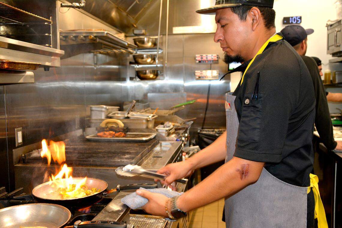 Sous chef Pedro Ayala cooks inside the newly constructed kitchen of Bistro 120 in Oakdale, Calif. Sept. 5, 2023.