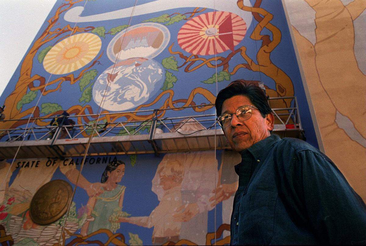 In June 1998, John Sierra and crew work on repainting his mural on the west side of the state employment building. 
