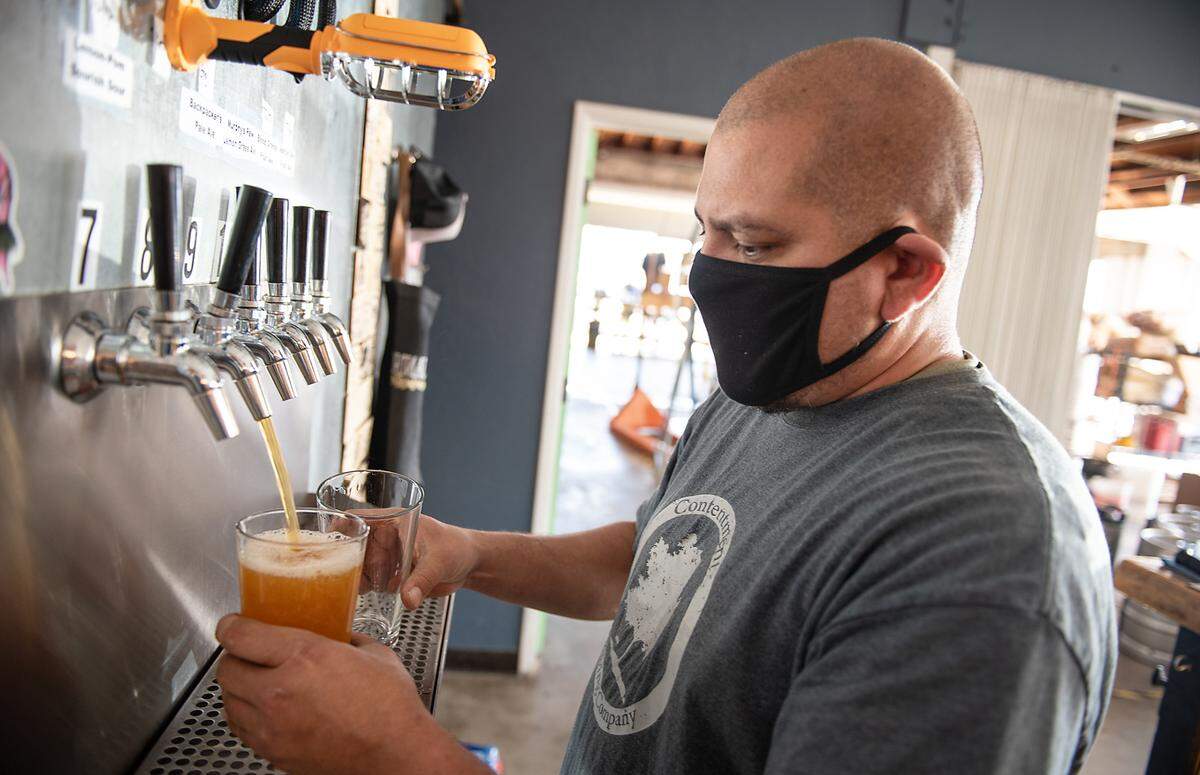 Owner Alejandro Serrato pours beer at contentment Brewing Co. in Modesto, Calif., on Saturday, March 6, 2021.