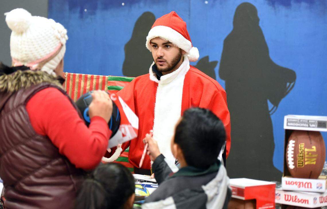 Volunteer Brolin Davidof gives out toys Friday afternoon (12-23-16) at the Modesto Gospel Mission’s Happy Birthday Jesus party in Modesto, Calif.