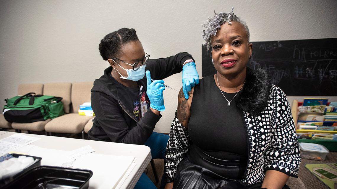 Gia Smith, right, gets a booster vaccine from RN Amina Edache at a vaccine clinic during the Modesto-Stanislaus NAACP Holiday Kwanzaa Social at Redeemer Modesto in Modesto, Calif., on Friday, Dec. 10, 2021.