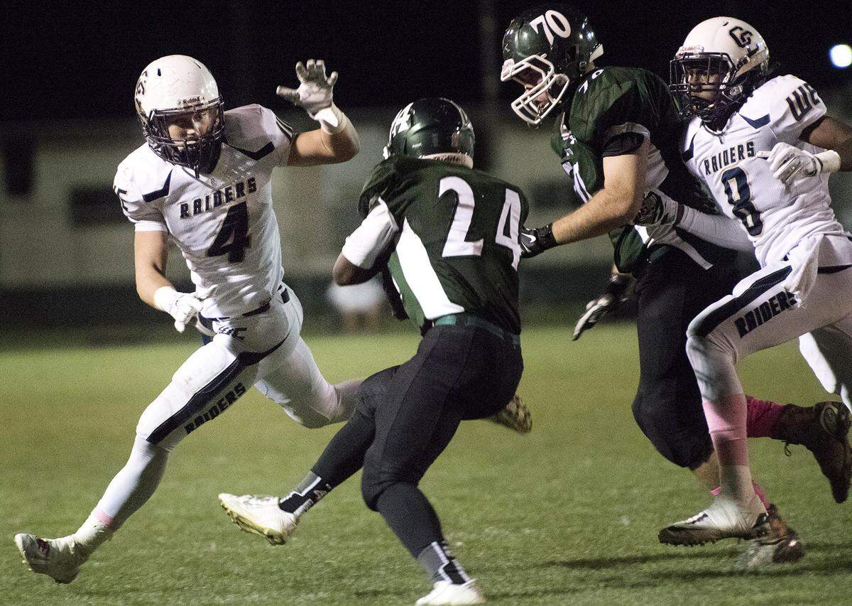 Central Catholic defensive end Luke Navarro (4) and defensive back Daron Bland track down Manteca running back Kameron Beamon during the Valley Oak League game at Manteca High School in Manteca, Calif., on Friday, October, 16, 2015. Central Catholic won the game 28-6.
