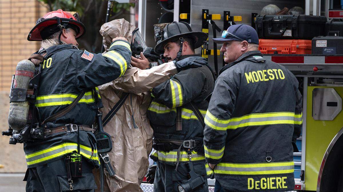 Firefighters prep a team member with a hazmat suit as the Modesto Fire Department’s hazmat team responds to a suspicious package at the Stanislaus County District Attorney’s Office in Modesto, Calif., Tuesday, Nov. 1, 2022. The Modesto City Fire Fighters Association has contributed $3,000 to the Measure H campaign, and the International Association of Fire Fighters has given $12,500.