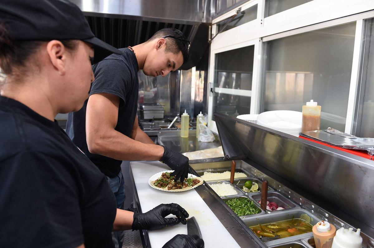 Alfonso Meraz makes tacos as Araceli Becerra stands by at left in the Fonzi’s Tacos food truck. Today is the first day of operation for Modesto Grub Hubs, the new food truck court at the corner of Ninth and G streets in downtown Modesto, Calif.