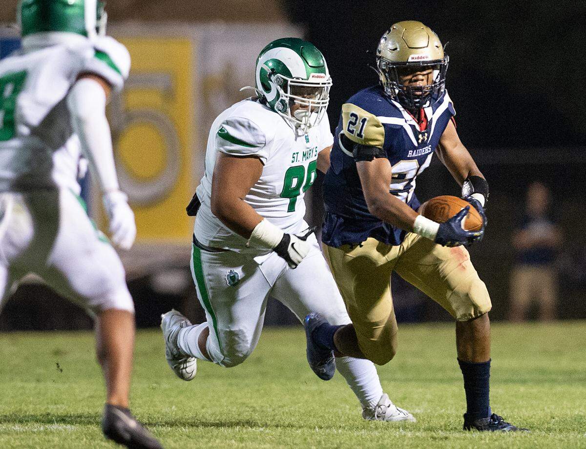 Central Catholic’s Joel Roberts runs the ball after a catch as St. Mary’s Gabriel Valeros pursues during the non-league game at Central Catholic High School in Modesto, Calif., on Friday, September 2, 2022.