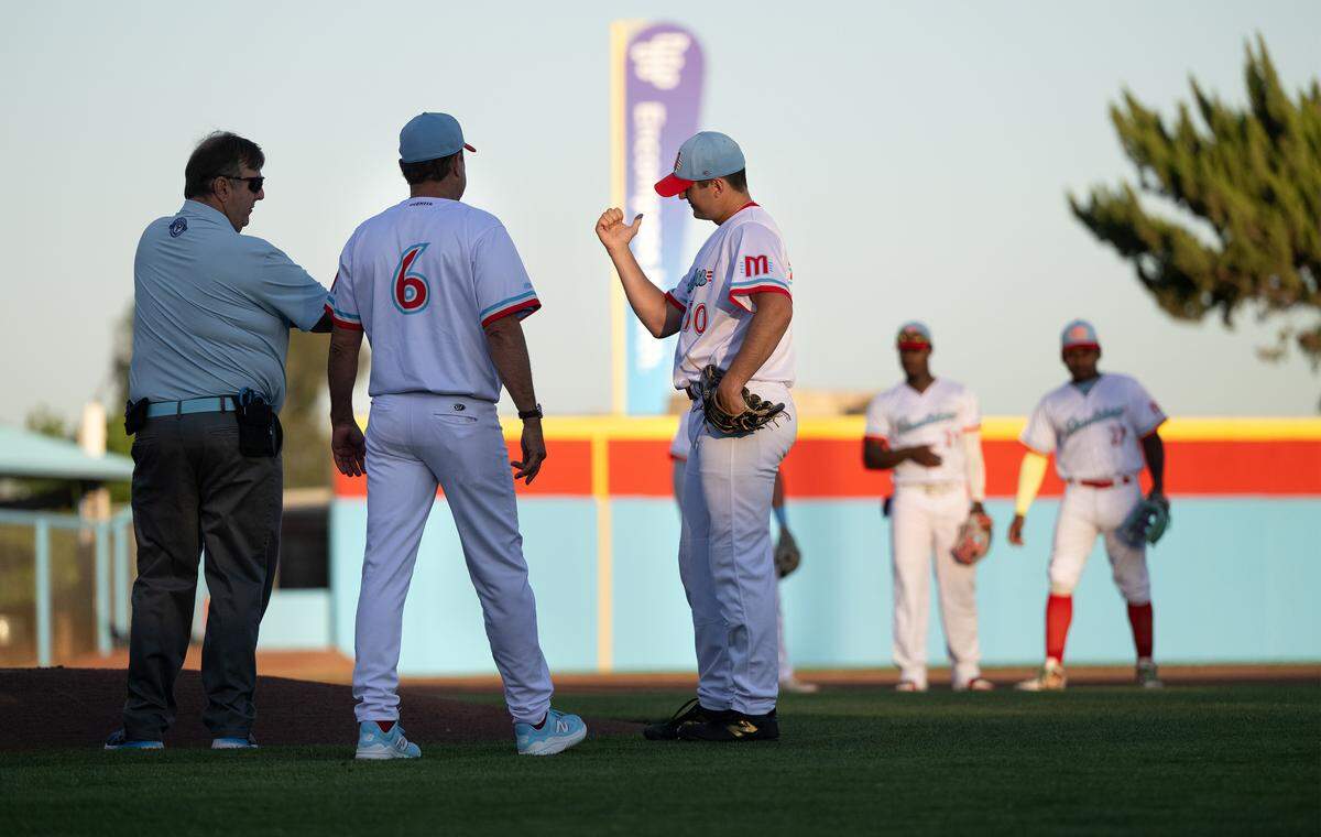 Modesto Roadsters manager J.T. Snow checks on pitcher Jonah Jenkins, who was hit by a piece of a broken bat during the Pioneer League game at Modern Woodmen Field in Modesto on Tuesday, May 19, 2026.